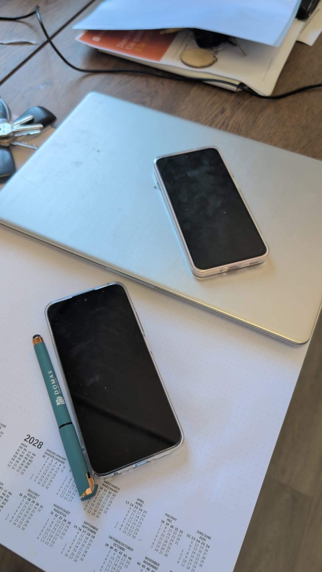 Due telefoni e una penna sulla scrivania